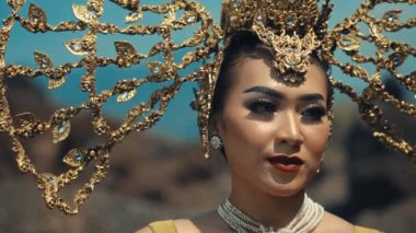 Geleneksel Tayland kıyafetleri içinde zarif bir kadın. Karmaşık altın başlık ve mücevherlerle. Gün ışığında kültürel güzellik kavramı.