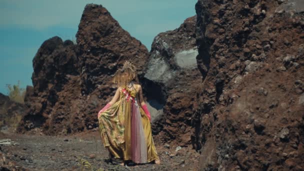 穿着传统服装的女人在白天走在巨大的火山岩之间 — 图库视频影像