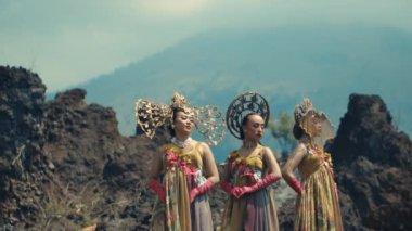 Gündüz vakti volkanik bir peyzaja karşı geleneksel kostümlü iki kadın