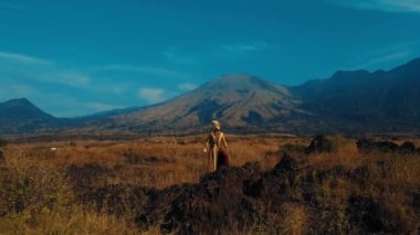 Uçsuz bucaksız bir arazide özgürlüğün tadını çıkaran bir gezgin. Arka planda görkemli bir dağ..