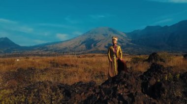 Yerli halk, engin bir tarlada altın saat boyunca arka planda heybetli bir dağla dikiliyor.