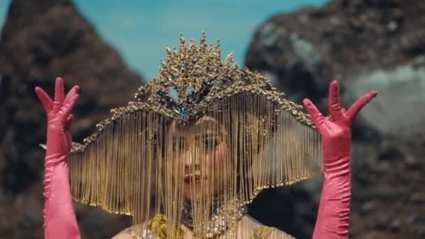 Mulher Elaborado Headpiece Dourado Luvas Rosa Posando Contra Fundo Rochoso — Vídeo de Stock