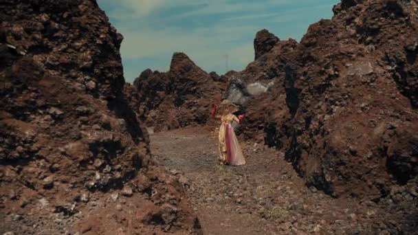 Femeie Într Rochie Curgătoare Mergând Între Roci Vulcanice Solide Sub — Videoclip de stoc