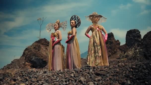 Three Women Artistic Costumes Headpieces Standing Rocky Landscape Portraying Fantasy — Stock Video