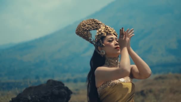 日中の山の背景にポーズするヘッドピースで伝統的な服装の女性 — ストック動画