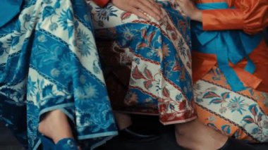 Karmaşık desenli geleneksel Asya kıyafetleri gün ışığında kumaş ve zarif tasarımlara odaklanıyor.