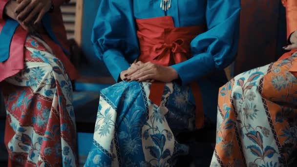 Two Women Traditional Korean Hanbok Dresses Sitting Hands Gently Resting — Stock Video