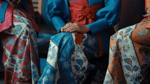 Kvinnor Traditionella Koreanska Hanbok Klänningar Sitter Med Händerna Försiktigt Placerade — Stockvideo