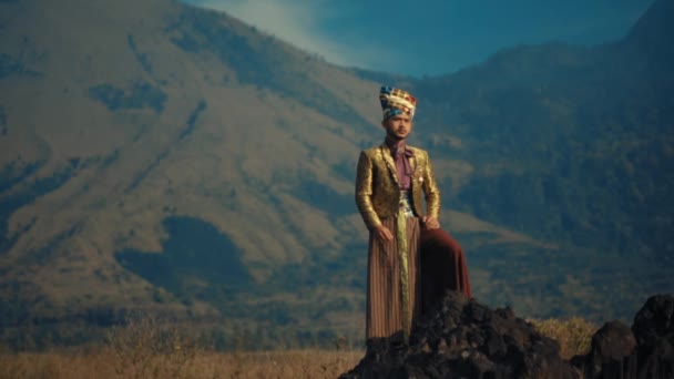 黄昏时分 身穿礼仪服装站在山景前的传统亚裔男子 — 图库视频影像