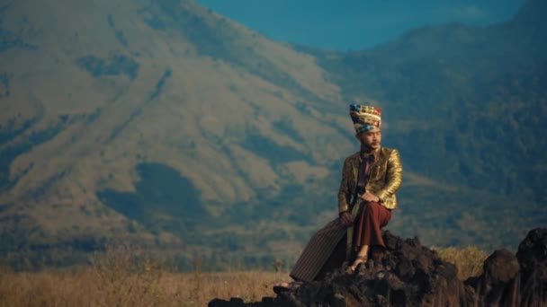 Πρόσωπο Παραδοσιακή Ενδυμασία Που Κάθεται Βράχους Ένα Βουνό Στο Βάθος — Αρχείο Βίντεο