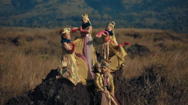 日中の山岳背景で屋外で行うカラフルな衣装の伝統的なダンサー — ストック動画