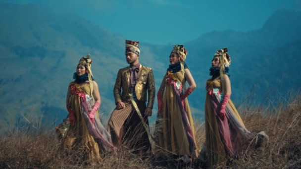 传统的皇家服装 白天以高山为背景的自然景观中的一群人 — 图库视频影像