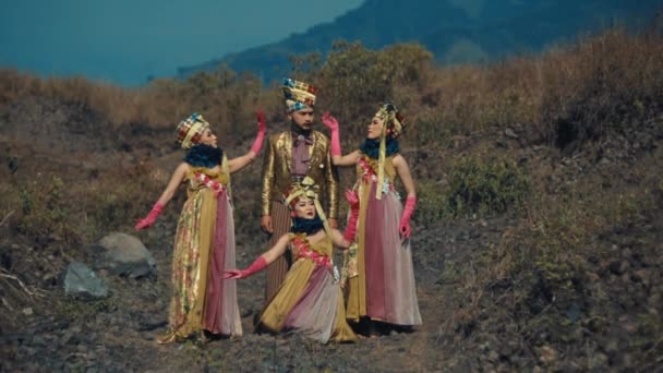 穿着华丽服装的传统舞蹈家在户外表演 白天有山地背景 — 图库视频影像