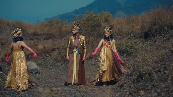 日中は山岳地帯を背景にアウトドアで踊る伝統衣装の3人 — ストック動画