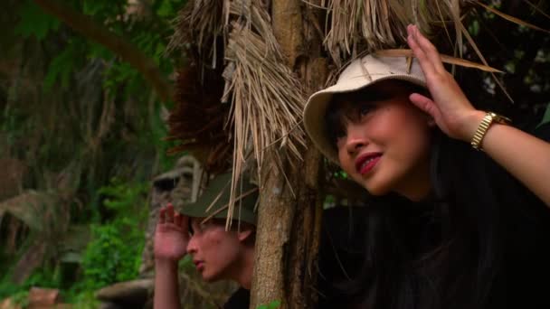 Δύο Άνθρωποι Στη Ζούγκλα Ντύνονται Κοιτάζοντας Μέσα Από Φύλλωμα Εκφράσεις — Αρχείο Βίντεο