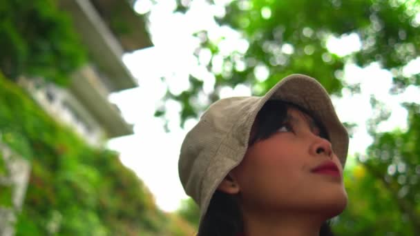Femme Chapeau Écharpe Regardant Vers Haut Avec Une Verdure Floue — Video
