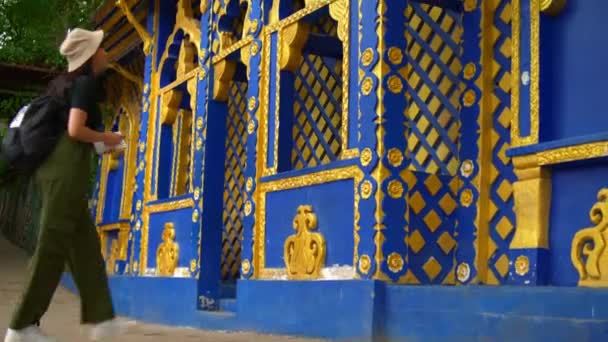 Turysta Podziwiający Zawiłe Niebiesko Złote Wzory Ścianie Świątyni Azji Południowo — Wideo stockowe