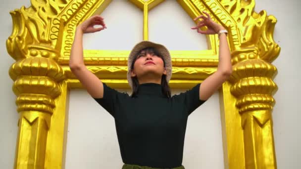 由一位金黄色的泰国传统庙宇拱门向游客展示文化建筑的女游客 — 图库视频影像