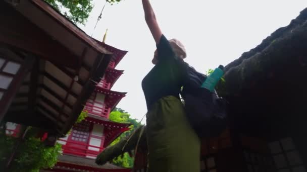 游客们背着背包欣赏着古老的亚洲寺庙 怀着敬畏的心情举起双臂 清晨被茂密的绿叶环抱着 — 图库视频影像