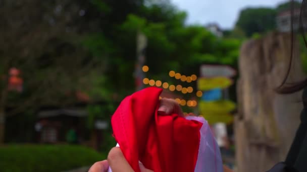 Detailní Záběr Ženy Držící Červenou Látku Rozmazaným Zeleným Pozadím Naznačující — Stock video