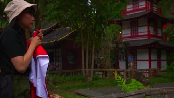 Turysta Kapeluszem Przechodzącym Obok Tradycyjnej Azjatyckiej Pagody Otoczony Bujną Zielenią — Wideo stockowe
