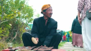 Turistlerin geçmişi, tarihi bir tapınak bölgesinde bulanık. Sabah boyunca ön planda canlı yeşil çimenler var.