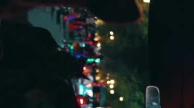 Gece Yogyakarta 'da hareket halindeki geleneksel bir araçtan alınan renkli şehir ışıkları ve trafik ışıklarının dikey açılı bir görüntüsü..