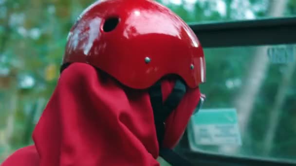 戴红色头盔和围巾的人的特写 背景模糊不清 暗示着白天活动或旅行 — 图库视频影像