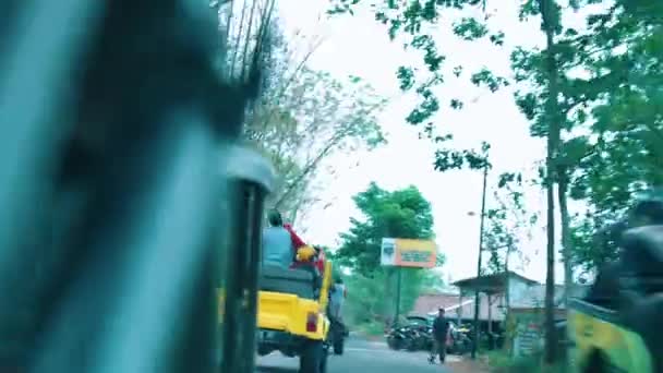 从一辆汽车上看到 早上人们骑在一辆黄色卡车的后座上 旁边停着摩托车 — 图库视频影像