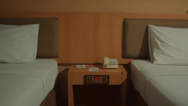 有两张单人床和一张床头柜 夜间有电话和钟表的对称酒店房间 — 图库视频影像