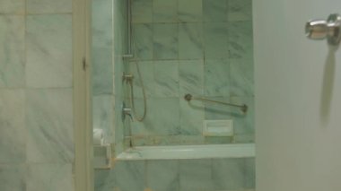 Modern banyo içi cam duş kapısı ve fayanslı duvarlarla dolu.