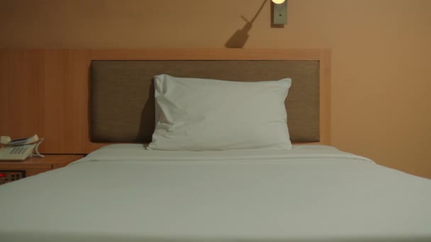 简约的旅馆房间里只有一个白色的枕头 还有温暖的灯光和床头灯 — 图库视频影像