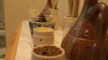 Mutfak rafındaki seramik kaselerde çeşitli baharatlar ve gece boyunca ön planda kırsal ahşap havan ve tokmak vardı.