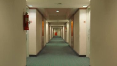 Boş otel koridoru, desenli halı, her iki tarafında kapılar ve gece boyunca yangın söndürücü.