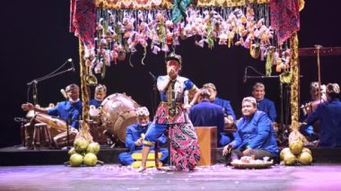 Müzisyenlerle geleneksel Asya performansı ve sahnede renkli bir palyaço, gece boyunca kültürel eğlence konsepti