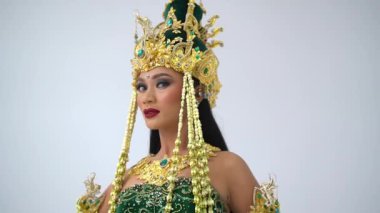 Tam teşekküllü bir Cava dansçısı, Endonezya kültürel güzelliğini sembolize ederek altın Siger tacını ayarlarken ince hareketler sergiliyor..