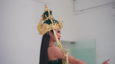 Geleneksel bir Cava tacının arkasına ve etnik kostümlü uzun siyah saçlı bir kadının saçına odaklanıyorum..