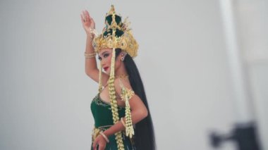 Geleneksel Balili dansçı süslü kostümlü. Düz bir zemine karşı anlamlı el hareketleriyle kültürel dans ediyor..