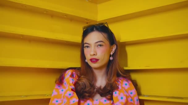 Mulher Elegante Vestido Floral Posando Contra Escada Amarela Exalando Confiança — Vídeo de Stock