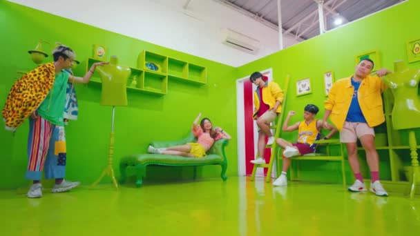 Grupo Jóvenes Moda Divirtiéndose Una Sala Verde Vibrante Con Muebles — Vídeo de stock