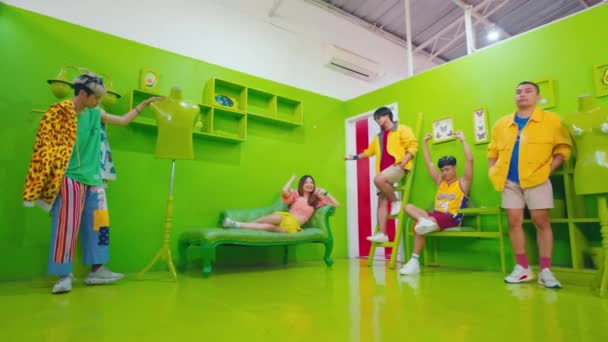 Grupo Jóvenes Moda Que Divierten Una Habitación Vibrante Colorida Con — Vídeo de stock