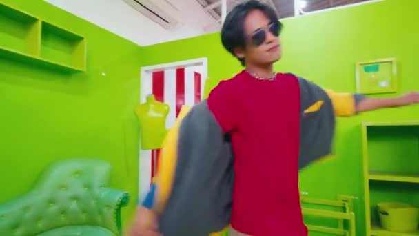 Young Men Dancing Vibrant Green Room One Colorful Outfit Other — Stock Video
