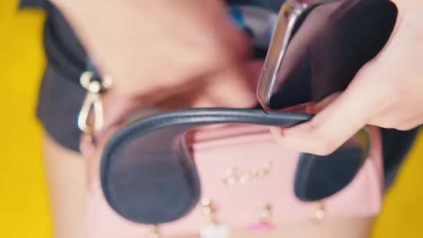 朝の間に個人的なアイテムとスタイリッシュなピンクの財布を保持している女性の手のクローズアップ — ストック動画