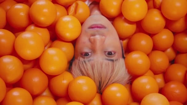 Portrait Créatif Une Personne Immergée Dans Des Boules Orange Vif — Video