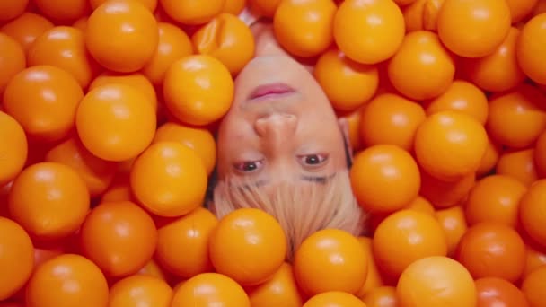 Portrait Créatif Une Personne Immergée Dans Des Boules Orange Vif — Video