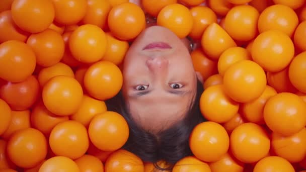 Πρόσωπο Βυθισμένο Μια Θάλασσα Από Λαμπερές Πορτοκαλί Μπάλες Μόνο Πρόσωπό — Αρχείο Βίντεο