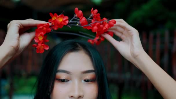 Close Person Adjusting Red Floral Headband Blurred Green Background Morning — Stock Video
