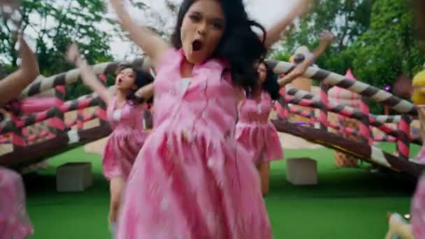 Ομάδα Κοριτσιών Ροζ Φορέματα Χορεύουν Εξωτερικούς Χώρους Ένα Παιχνιδιάρικο Σκηνικό — Αρχείο Βίντεο