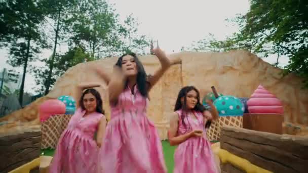 Дві Дівчини Рожевих Сукнях Танцюють Примхливій Відкритій Обстановці Великими Реквізитами — стокове відео