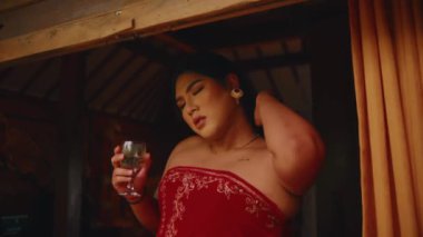 Sabahları yemyeşil yemyeşil ağaçlarla çevrili ahşap bir kulübede tropikal bir manzaranın tadını çıkaran bir insan.